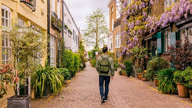 Rear view of a man walking among mews houses in South Kensington district, London, UK